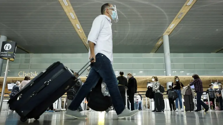 Un hombre protegido contra el Covid anda por un aeropuerto. EFE
