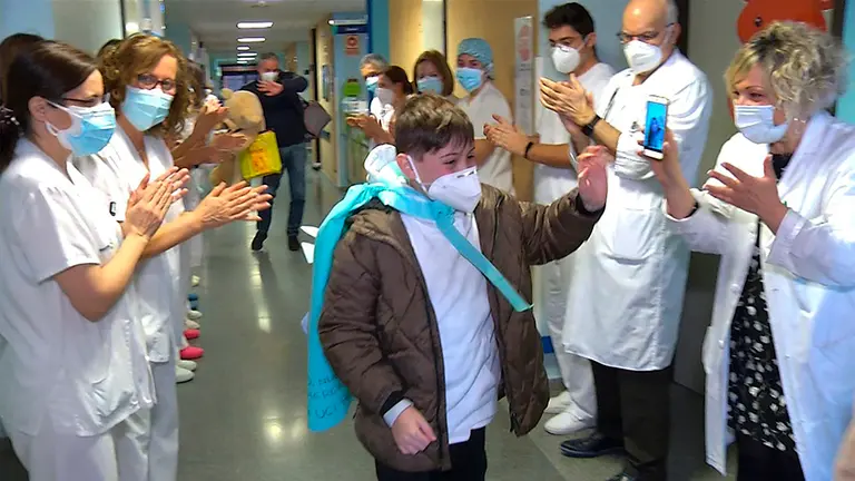 El personal sanitario del Hospital Mancha Centro de Alcázar de San Juan (Ciudad Real) se despide de Mateo (c), el niño que estuvo 11 días ingresado en la UCI afectado por el coronavirus y que ha recibido este viernes el alta médica. EFE
