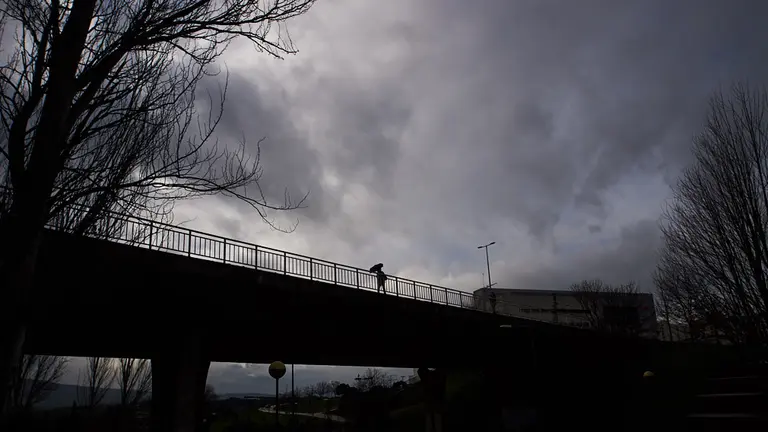 Una mujer con paraguas camina por las calles de Pamplona un dia de lluvia durante la tercera ola del coronavirus. MIGUEL OSÉS