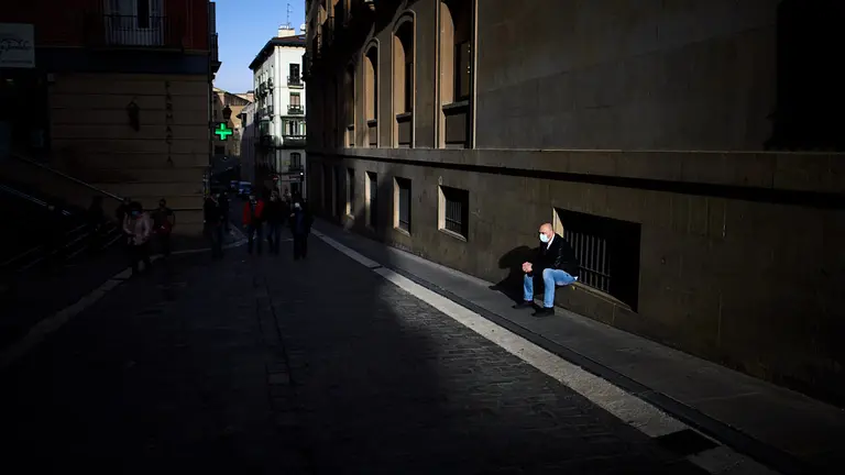 Un hombre espera sentado en Santo Domingo durante la tercera ola del coronavirus en Pamplona. MIGUEL OSÉS