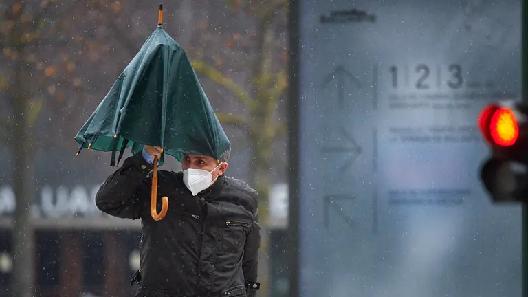 Un hombre con un paraguas bajo la lluvia durante la tercera ola de coronavirus en la Comunidad Foral de Navarra. MIGUEL OSÉS