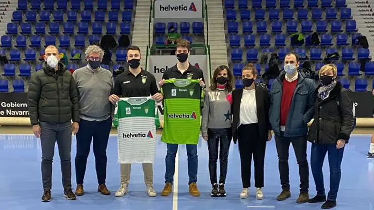 Aitor García y Maxi Cancio sostienen sus camisetas en la pista del pabellón Anaitasuna