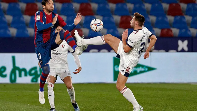 El defensa del Levante UD, Toño García, y el centrocampista del CA Osasuna, Jon Moncayola, luhan por el balón durante el partido correspondiente a la 23ª jornada de Liga disputado esta tarde en el estadio Ciutat de Valencia. EFE/Manuel Bruque