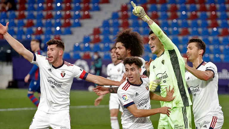 El portero del CA Osasuna, Sergio Herrera, celebra con sus compañeros el penalti detenido al jugador del Levante UD, Morales, durante el partido correspondiente a la 23ª jornada de LaLiga que Levante y Osasuna disputan hoy domingo en el estadio Ciutat de Valencia. EFE/Manuel Bruque