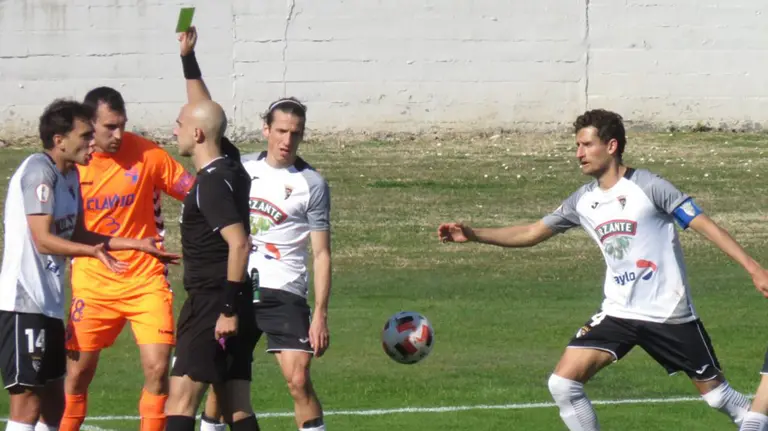 El árbitro Miguel Bosch Domenech muestra una tarjeta en el partido Tudelano - Ebro