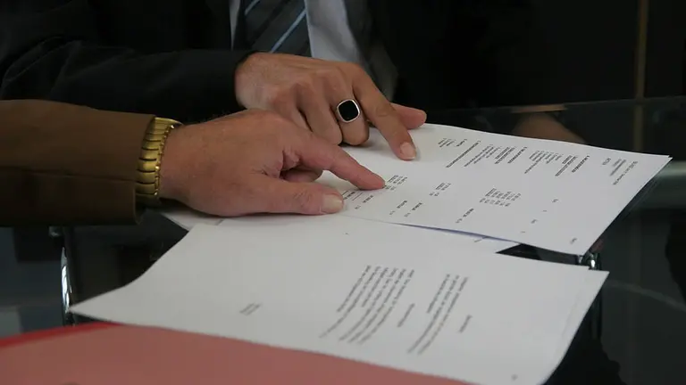 Dos personas firman un documento. ARCHIVO