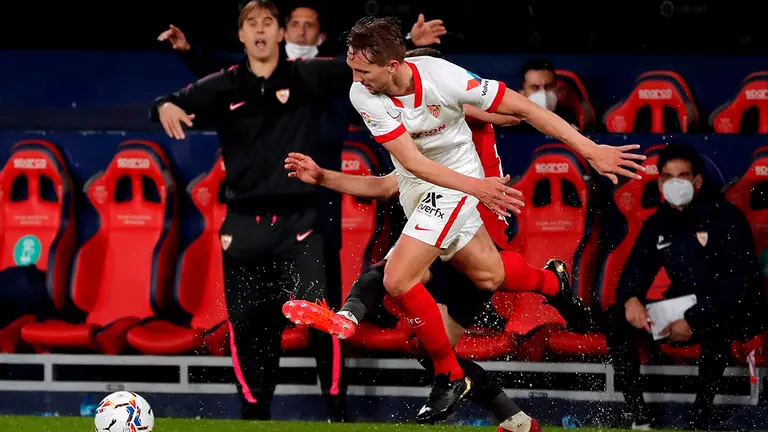 El delantero holandés del Sevilla, Luuk de Jong, disputa el balón ante un jugador de Osasuna durante el partido de Liga en Primera División disputado hoy Lunes en el estadio de El Sadar, en Pamplona. EFE/Villar López