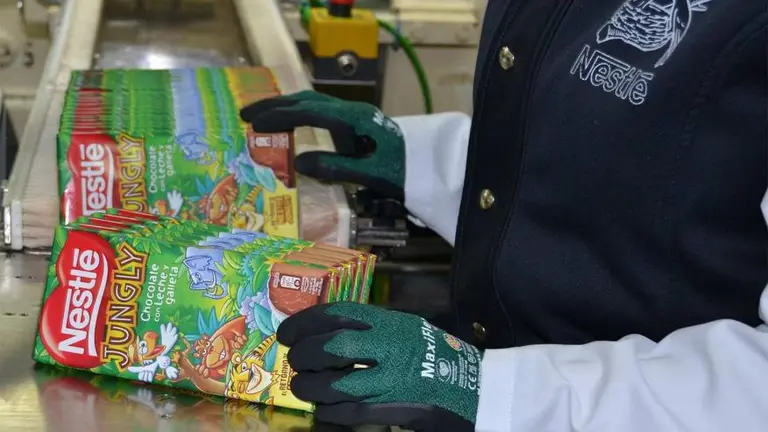 Un trabajador de Nestlé con varias tabletas de chocolate Jungly.