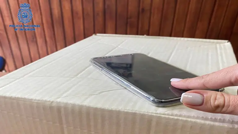 Imagen de un paquete junto con un móvil. POLICÍA NACIONAL