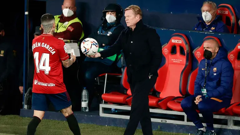 El entrenador del FC Barcelona, Ronald Koeman, entrega el balón a Rubén García (i), de Osasuna, durante el partido de Liga en Primera División que disputan esta noche en el estadio de El Sadar, en Pamplona. EFE/Jesús Diges
