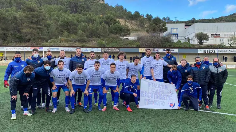 Jugadores y cuerpo técmico del izarra posan con camisetas y pancarta de apoyo a su compañero lesionado Álex Hinojosa. @CD_Izarra