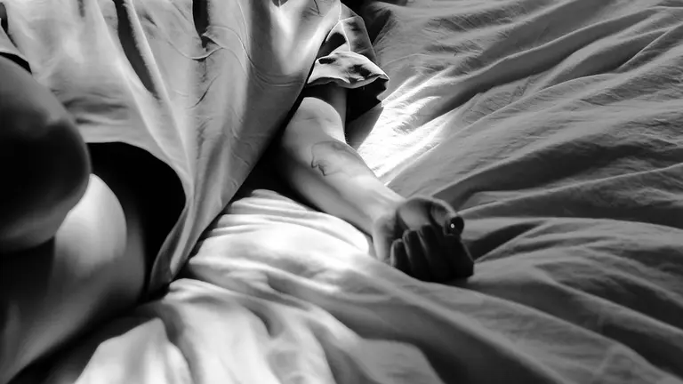 Una mujer tirada en la cama. ARCHIVO