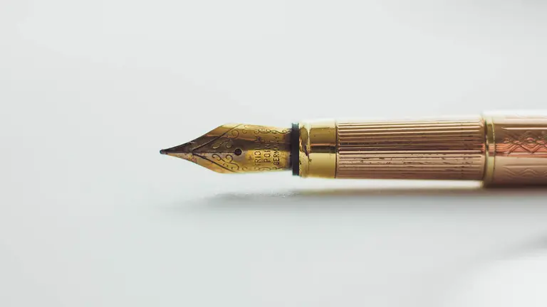 Una pluma de escribir sobre un folio en blanco. ARCHIVO