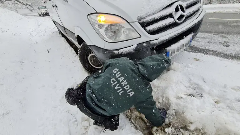 Un agente de la Guardia Civil ayuda a un vehículo tras una salida de vía en una carretera navarra. GUARDIA CIVIL