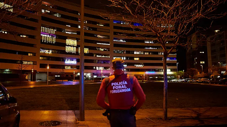 Un policía foral observa la plaza en la calle Londres, atendiendo una llamada por música alta. PABLO LASAOSA