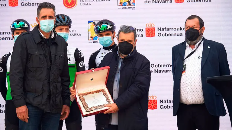 El director navarro del equipo Kern Pharma, Manolo Azcona (c), recibe un reconocimiento del director del club ciclista estellés Miguel Ángel García (d) y el pentacampeón del Tour de Francia Miguel Induráin (i) antes de comenzar la XXIII edición del Gran Premio de Induráin que discurre por tierras navarras, este sábado. EFE/Iñaki Porto