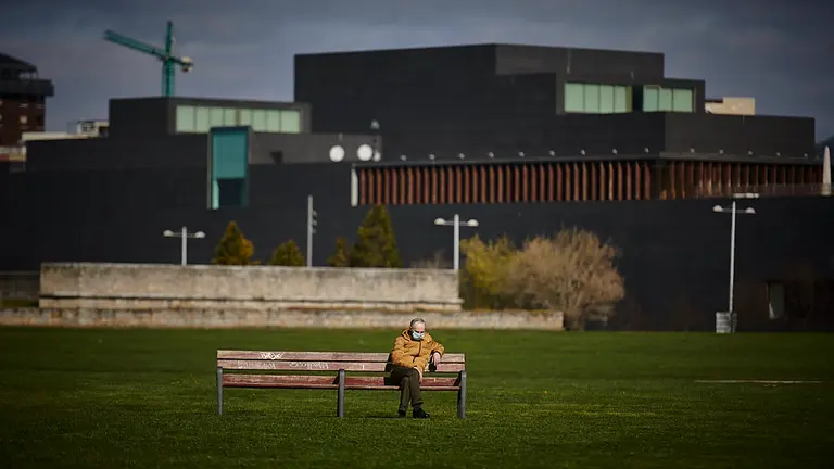 Un señor con mascarilla descansa sentado en un banco de la Vuelta del Castillo. PABLO LASAOSA
