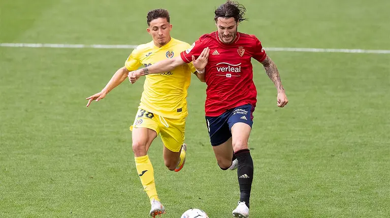 Juan Cruz en pugna por el balón junto a un jugador del Villarreal CA Osasuna.