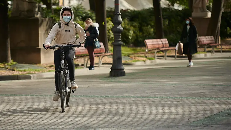 Una persona anda en bicicleta por Pamplona con mascarilla para evitar propagar el coronavirus. PABLO LASAOSA