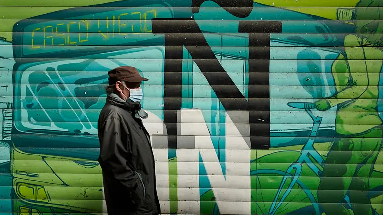Una persona camina por Pamplona con mascarilla para evitar propagar el coronavirus. PABLO LASAOSA
