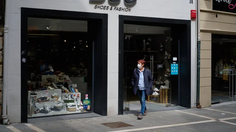 Varias personas pasean con mascarillas por las calles de Pamplona y sus comercios durante la pandemia del coronavirus. MIGUEL OSÉS