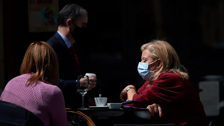 Una mujer con mascarilla sentada en una terraza durante la crisis del coronavirus en la Comunidad Foral de Navarra. MIGUEL OSÉS