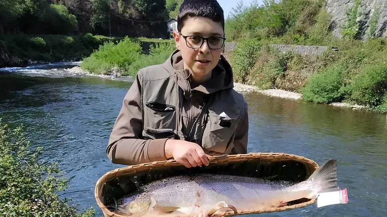 El pescador Ismael García Fernández muestra el primer salmón capturado esta temporada en el Bidasoa. GOBIERNO DE NAVARRA