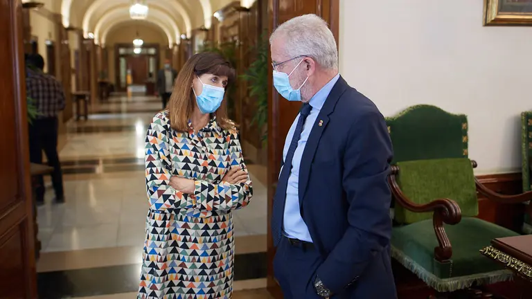 La concejala del PSN, Maite Esporrín, habla con el concejal de Navarra Suma, Juan José Echeverría, durante el pleno del Ayuntamiento de este jueves. MIGUEL OSÉS