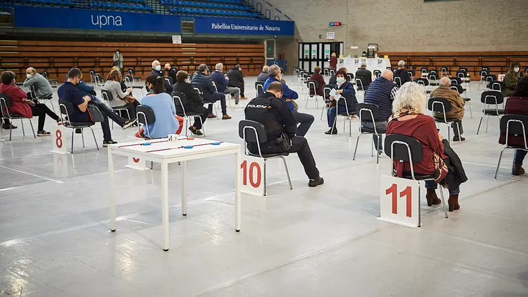 Varias personas esperan después de haberse puesto la vacuna del coronavirus en la UPNA de Pamplona. PABLO LASAOSA