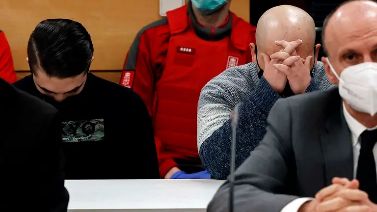 GRAFCAV5462. PAMPLONA, 24/05/2021.- La Audiencia Provincial de Navarra acoge desde este lunes el juicio con jurado por un triple crimen perpetrado en Cáseda en septiembre de 2018, tras el enfrentamiento entre dos familias. En sus conclusiones provisionales, el fiscal solicita 60 años de prisión —20 por cada uno de los tres delitos de asesinato— para los tres acusados —padre y dos hijos— de la muerte de Fermín J.E., de 50 años, y de dos de sus hijos, José Antonio y Cristian, de 20 y 17 años, quienes fallecieron a consecuencia de los disparos de escopeta recibidos. En la imagen, en primer termino uno de los abogados de los acusados (d) y detrás dos de los tres procesados.  EFE/ Jesús Diges Pool
