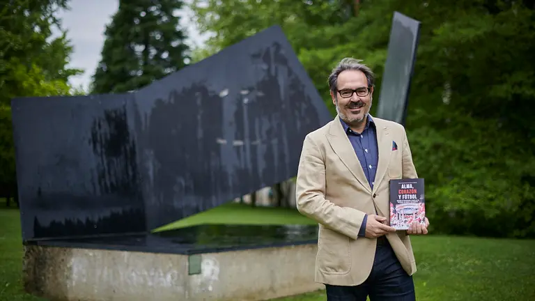 José Francisco Alenza con su libro sobre el Centenario de Osasuna titulado "Alma, corazón y fútbol". PABLO LASAOSA