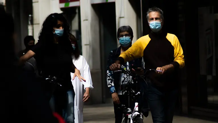 Varias personas pasean por las calles de Pamplona con mascarilla por la pandemia del COVID-19, a poco más de una semana de su retirada en exteriores. MEGAN WALLS