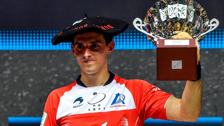 El delantero guipuzcoano Jokin Altuna en el podio tras vencer  hoy al zaguero también guipuzcoano Beñat Rezusta por 22-5 en la final del Campeonato Manomanista 2021 disputada este domingo en el frontón Bizkaia de Bilbao. EFE/Miguel Toña