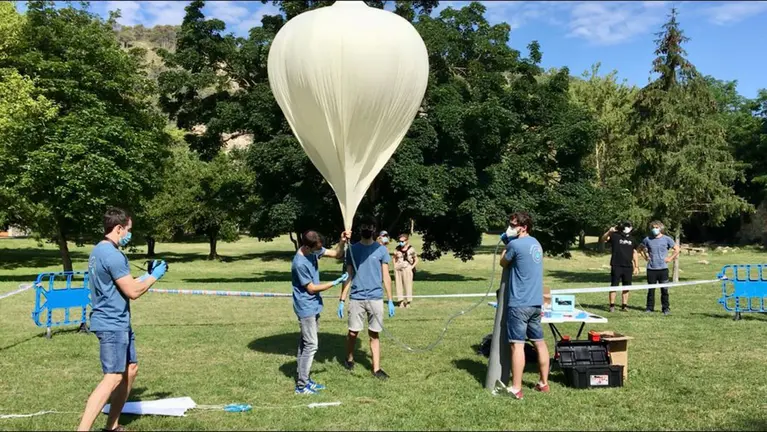 Los tres jóvenes se disponen a hinchar el globo instantes antes de su fortuito despegue. IMAGEN DE ARCHIVO