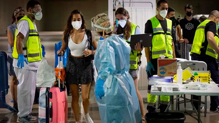Jóvenes procedentes de zonas de veraneo como Salou (Tarragona), a su llegada hoy sábado a la estación de autobuses de Pamplona donde continúa la recogida de pruebas Covid con un elevado nivel de participación. EFE/Villar López.