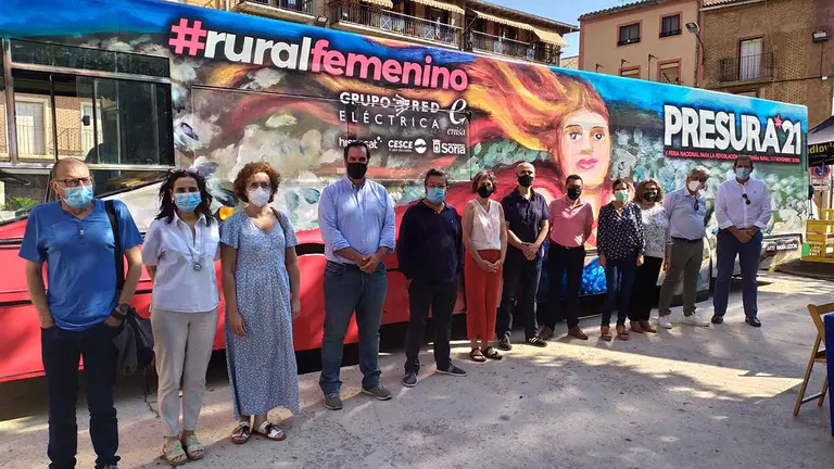 La consejera Esnaola, autoridades locales, participantes en la mesa redonda y responsables de la iniciativa posan junto al autobús. GOBIERNO DE NAVARRA