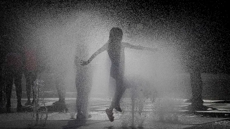 Una niña se refresca en una fuente de Pamplona en una jornada en la que está siendo el día más caluroso en lo que va de año en la capital navarra, con temperaturas de 38 y 39 grados. La Agencia Estatal de Meteorología (Aemet) ha dado aviso naranja por elevadas temperaturas en gran parte de Navarra, alerta que se extiende hasta mañana viernes aunque baja de nivel para una parte de la comunidad. EFE/Villar López