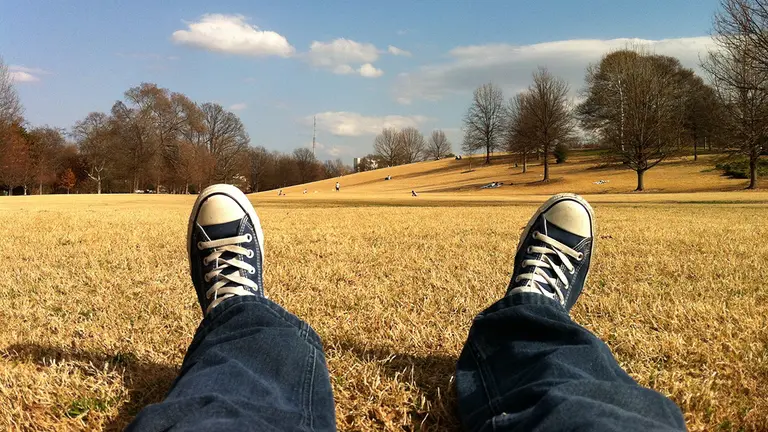 Una persona descansa tumbada en un parque. ARCHIVO