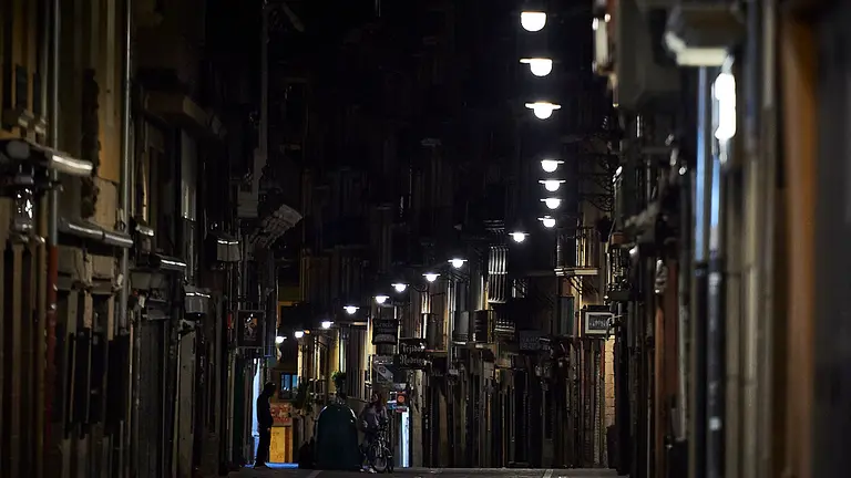 Varias personas caminan por la calle Estafeta de Pamplona minutos antes del toque de queda impuesto hasta septiembre a causa de la quinta ola del coronavirus. PABLO LASAOSA