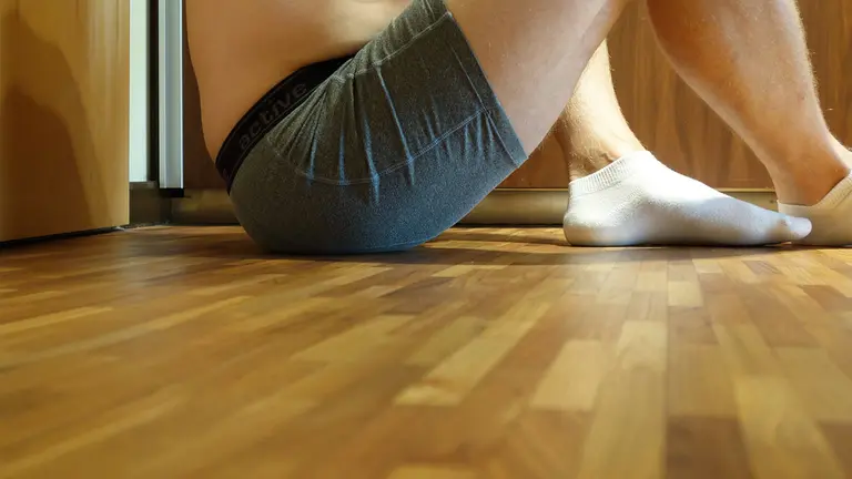 Un hombre sentado en el suelo en calzoncillos. ARCHIVO