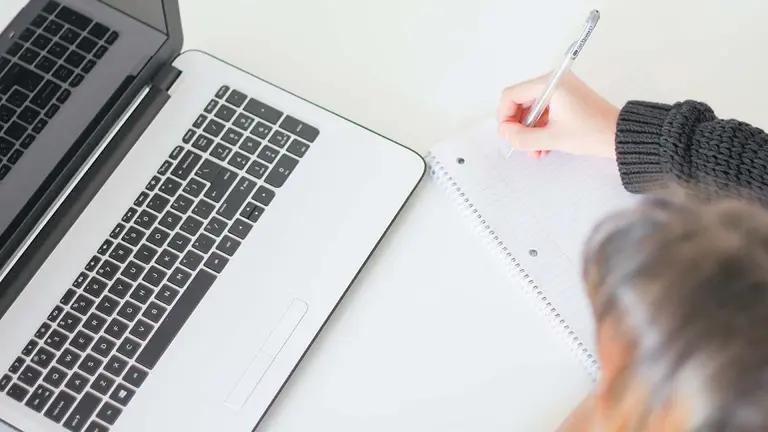 Una persona escribe en un cuaderno. ARCHIVO