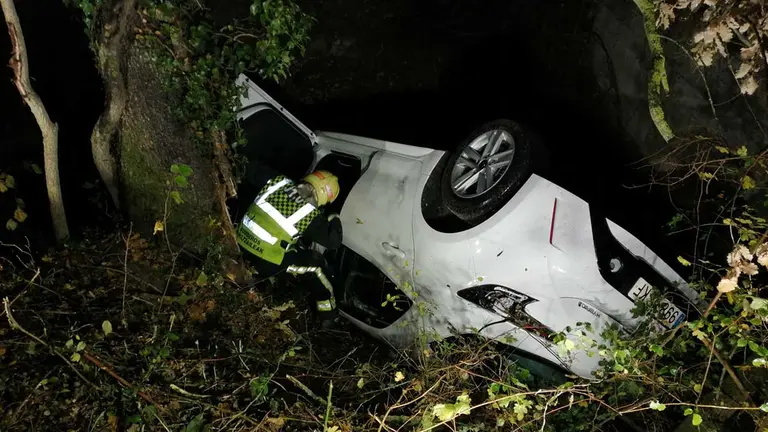 Los bomberos trabajan en el vehículo accidentado en Ibiricu. BOMBEROS DE NAVARRA