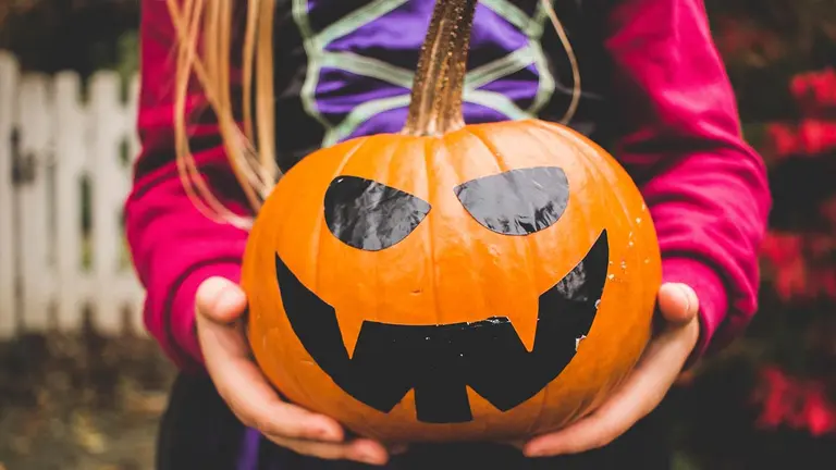 Una menor sujeta una calabaza en Halloween. ARCHIVO