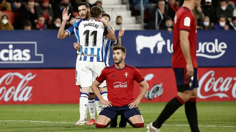 El centrocampista de la Real Sociedad, Mikel Merino (detrás) celebra la consecución del primer gol de su equipo ante Osasuna durante el partido de LaLiga correspondiente a la jornada decimotercera de primera división disputado hoy domingo en el estadio de El Sadar, en Pamplona. EFE / Jesus Diges.