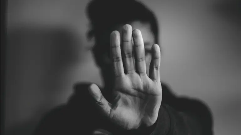 Una mujer hace el símbolo de STOP con la mano. ARCHIVO