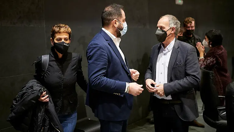 Ramón Alzórriz, del PSN, habla con Adolfo Araiz, de EH Bildu, mientras María Chivite accede a su asiento. PABLO LASAOSA