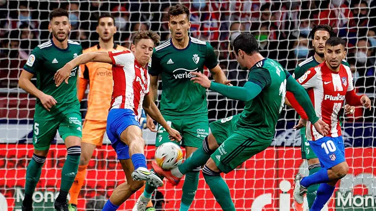 El centrocampista del Atlético de Madrid Marcos Llorente (i) lucha con Kike Gracía, de Osasuna, durante el partido la jornada 14 de LaLiga que Atlético de Madrid y Osasuna disputan hoy sábado en el estadio Wanda Metropolitano, en Madrid.- EFE/ZIPI