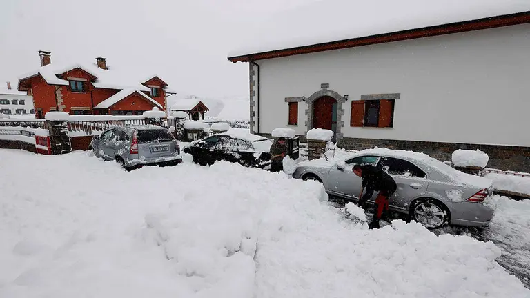 RONCESVALLES (NAVARRA), 28/11/2021.- Varias personas retiran la nieve que impide salir con sus vehiculos a la carretera de la localidad de Espinal en una jornada donde tras la intensa nevada caída en las últimas horas ha dejado espesores de nieve de mas de 40 centimetros en la zona. EFE/Jesús Diges
