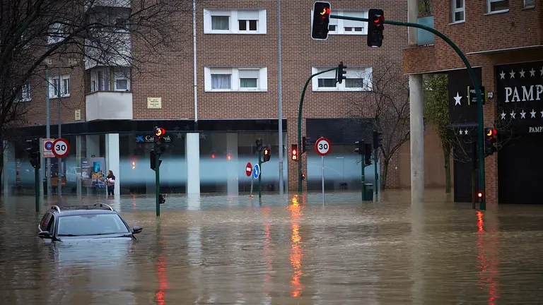 El río Arga se ha desbordado en el barrio de la Rochapea en Pamplona, con numerosas incidencias en diversas zonas con calles y garajes anegados y carreteras cortadas. IÑIGO ALZUGARAY
