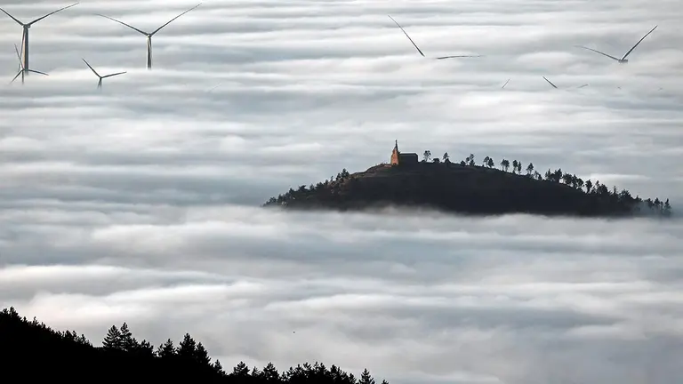 Amanecer desde el alto de El Perdón, donde la niebla deja al descubierto la ermita de San Martín de Añorbe. EFE/ Jesús Diges